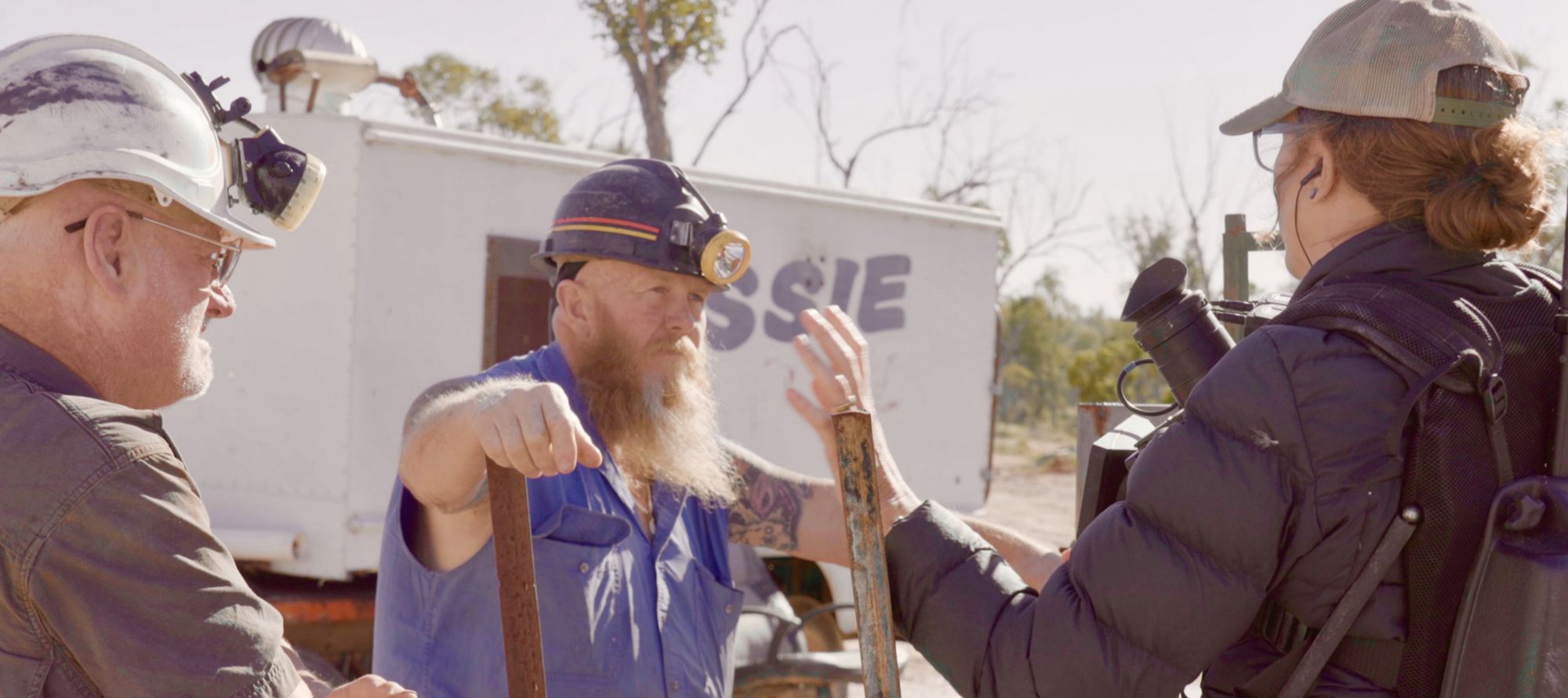 Olivia interviewing two opal miners beside a caravan