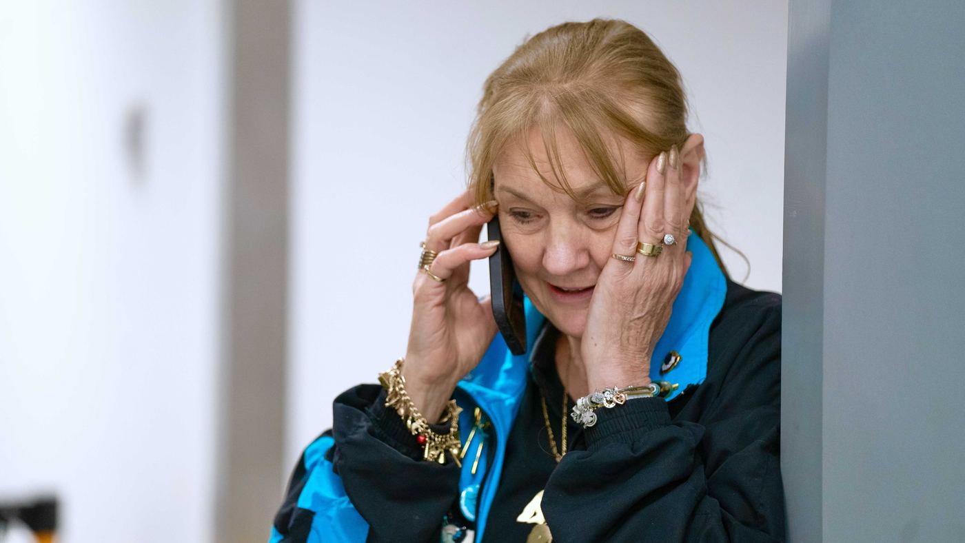 A woman on the phone, hand to her head